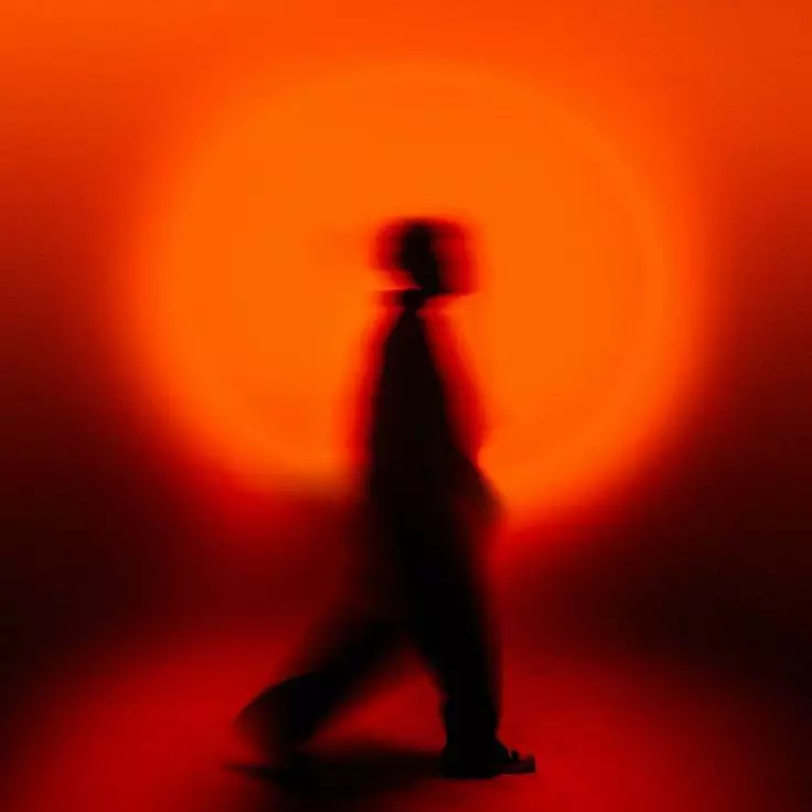 Silhouetted figure crossing an orange sun — Kerning Studio