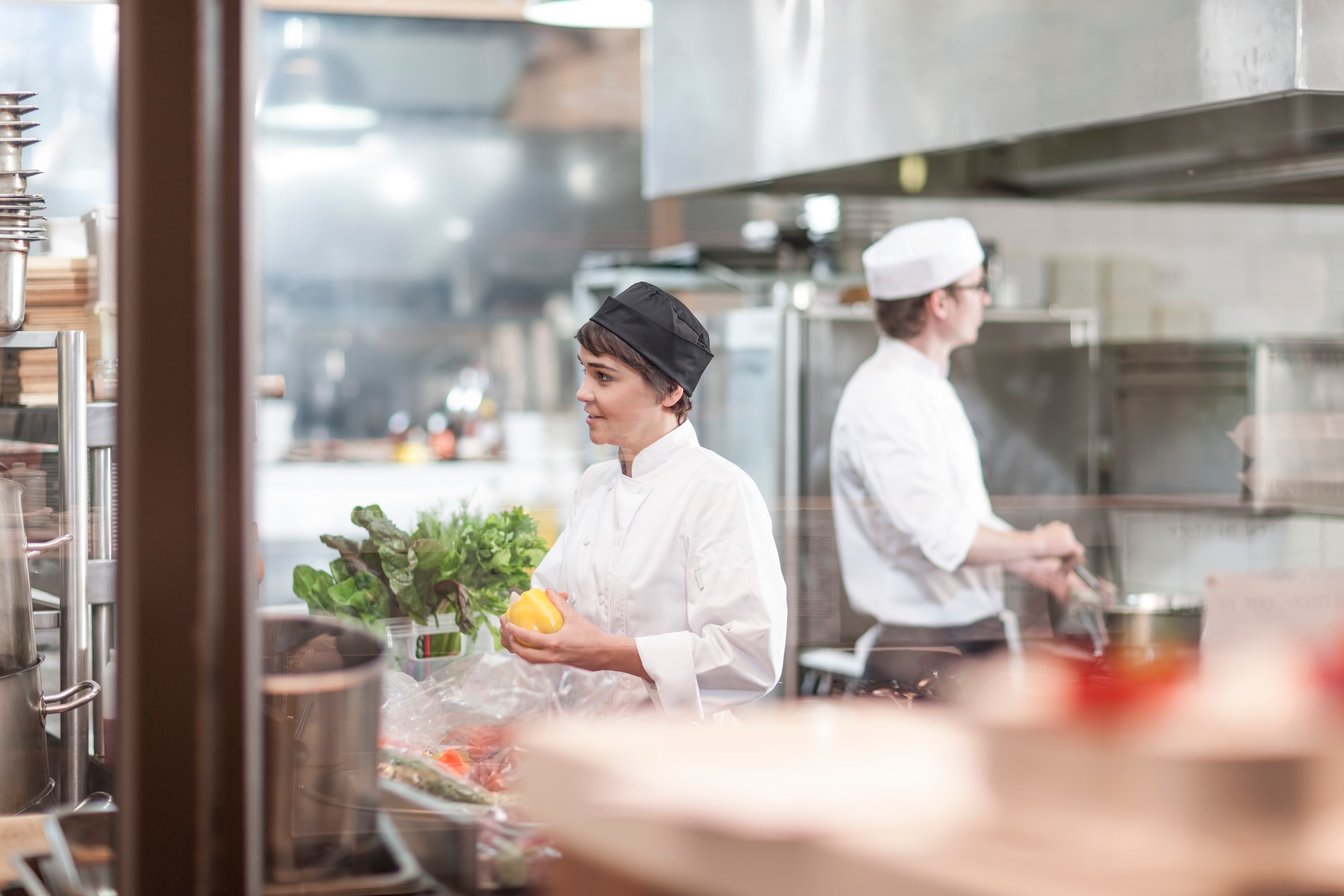 Two chefs working through a stainless pass — Keystonne